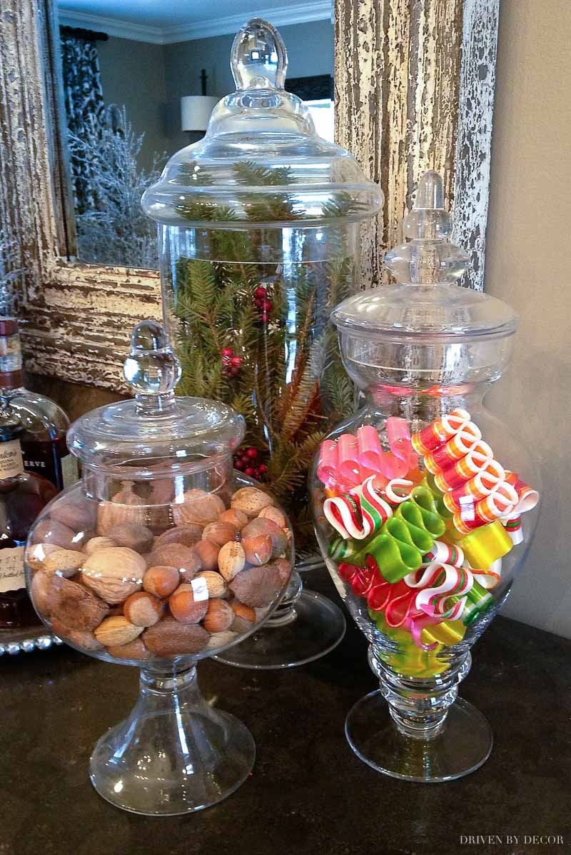 Apothecary jars filled with nuts, ribbon candy, and greenery for Christmas!