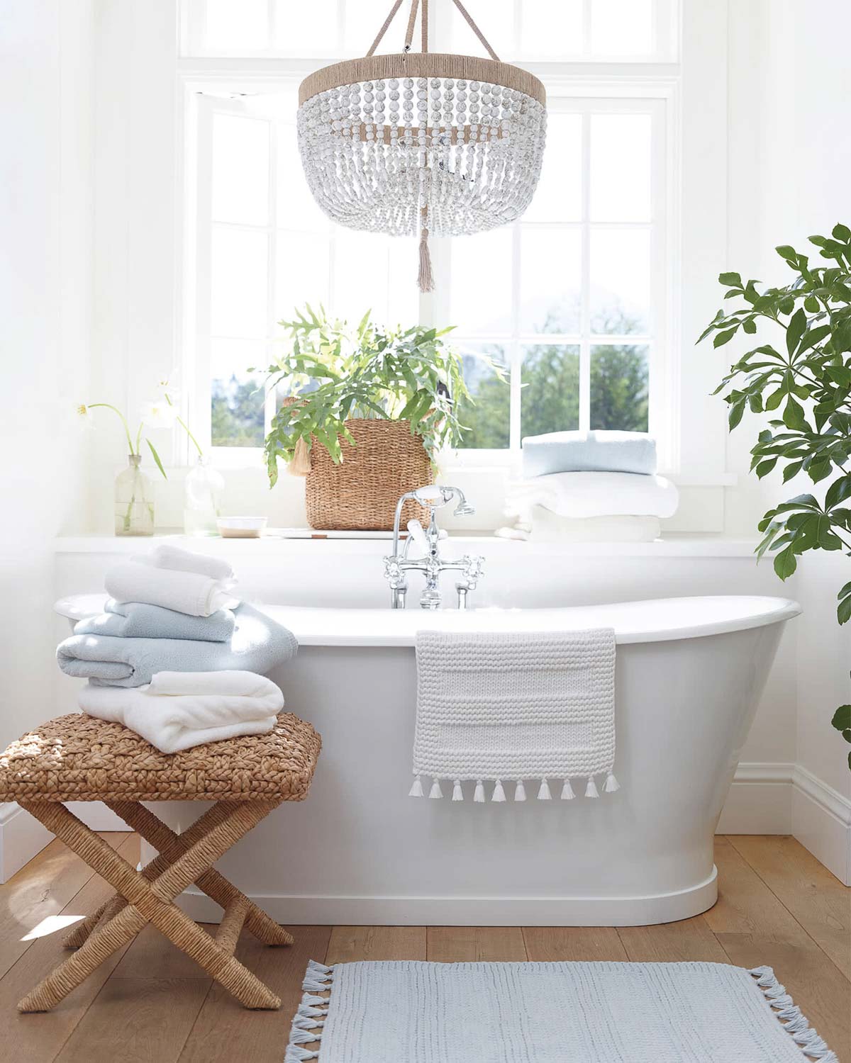 Bathroom with X-base stool in front of freestanding white tub