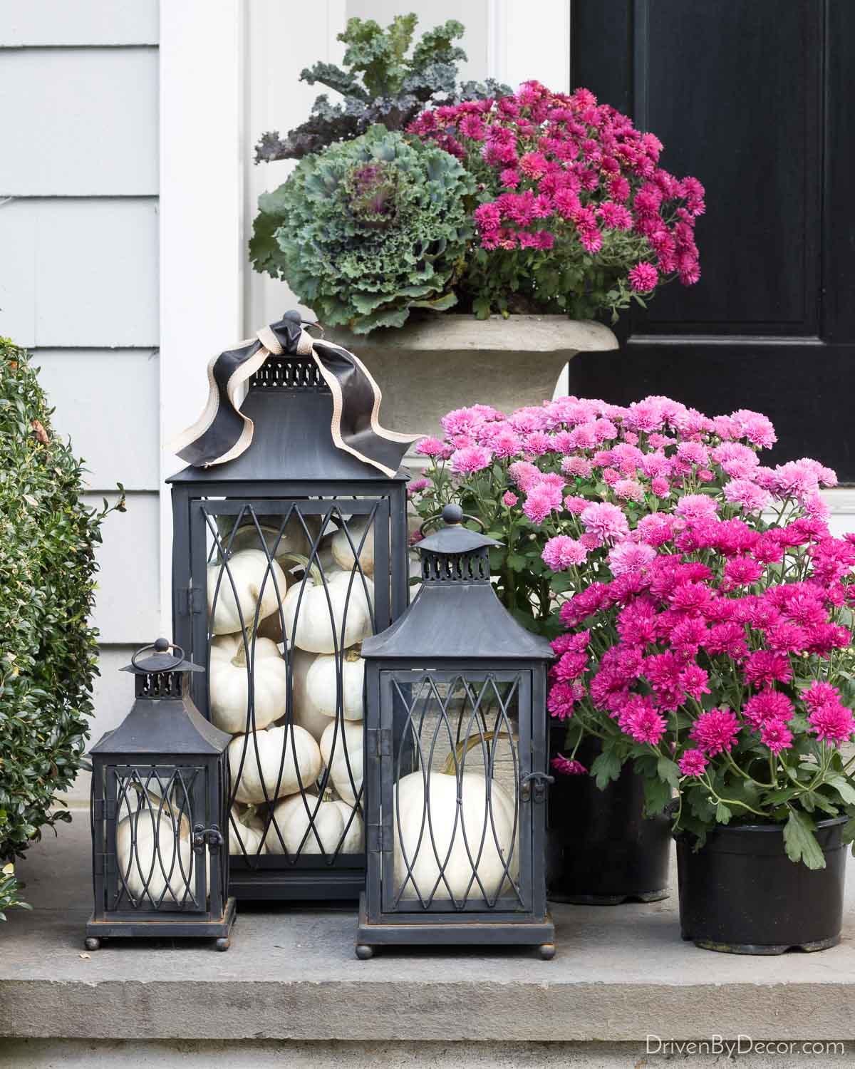 A trio of lanterns filled with pumpkins for fall decor on our front steps