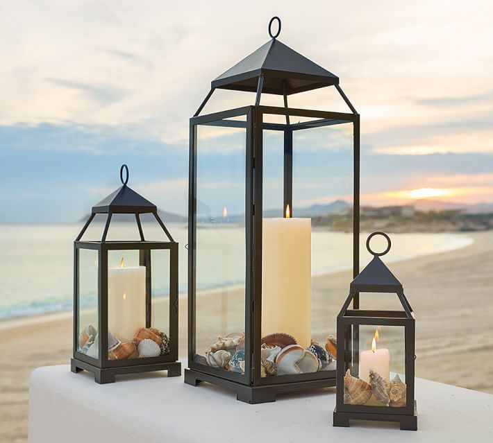 Seashells surround the candles in the base of this trio of lanterns - love this lantern decor idea!