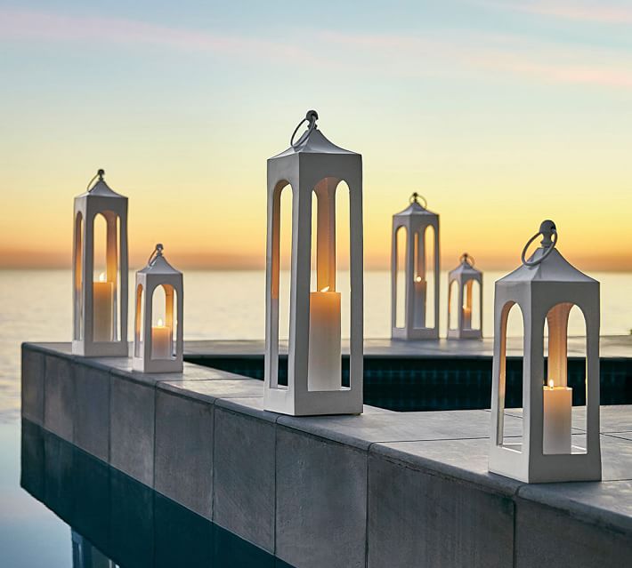 Lit lanterns lining a pool, patio, or porch