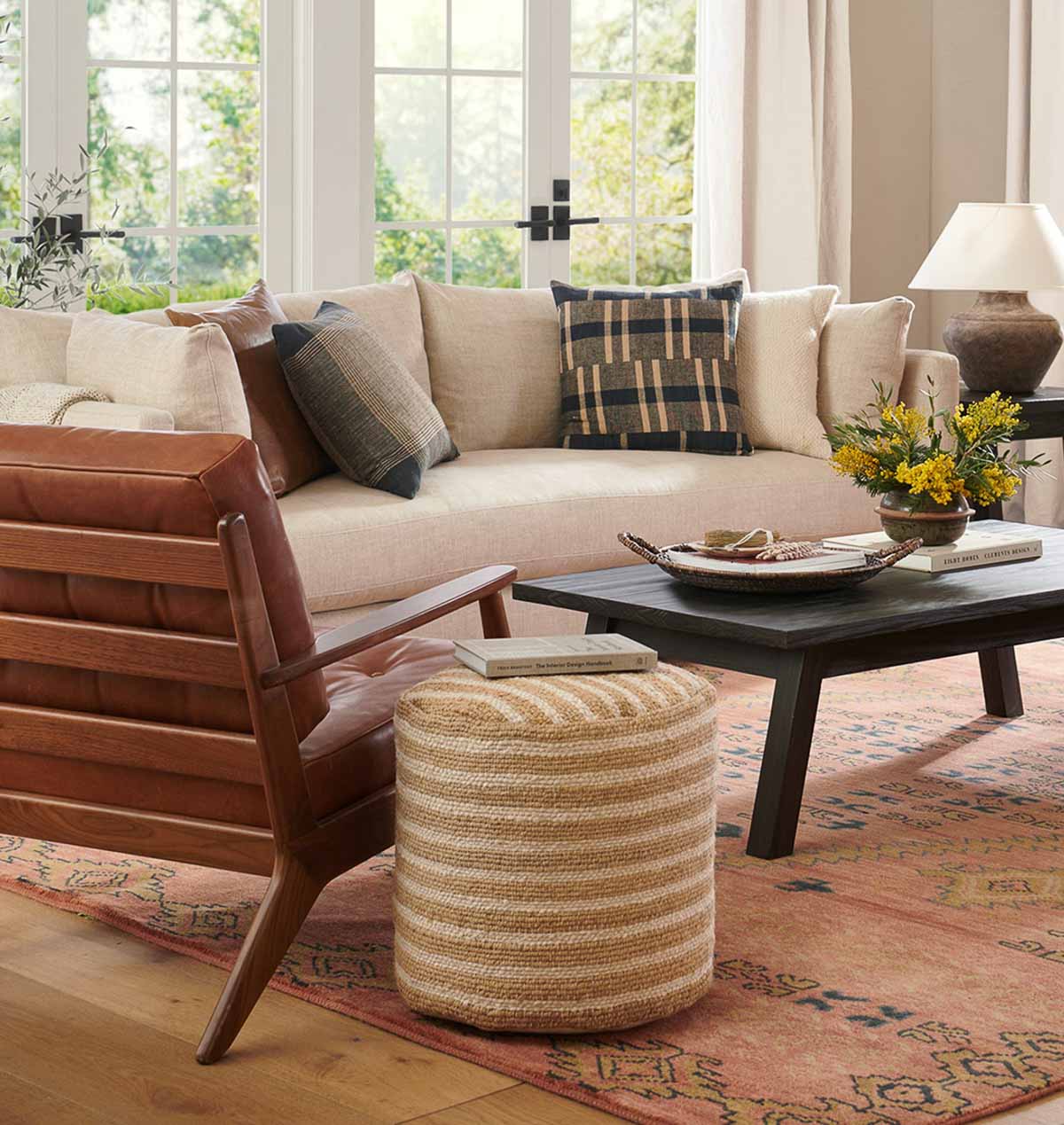 Striped jute pouf used as a side table - an example of decorating with poufs