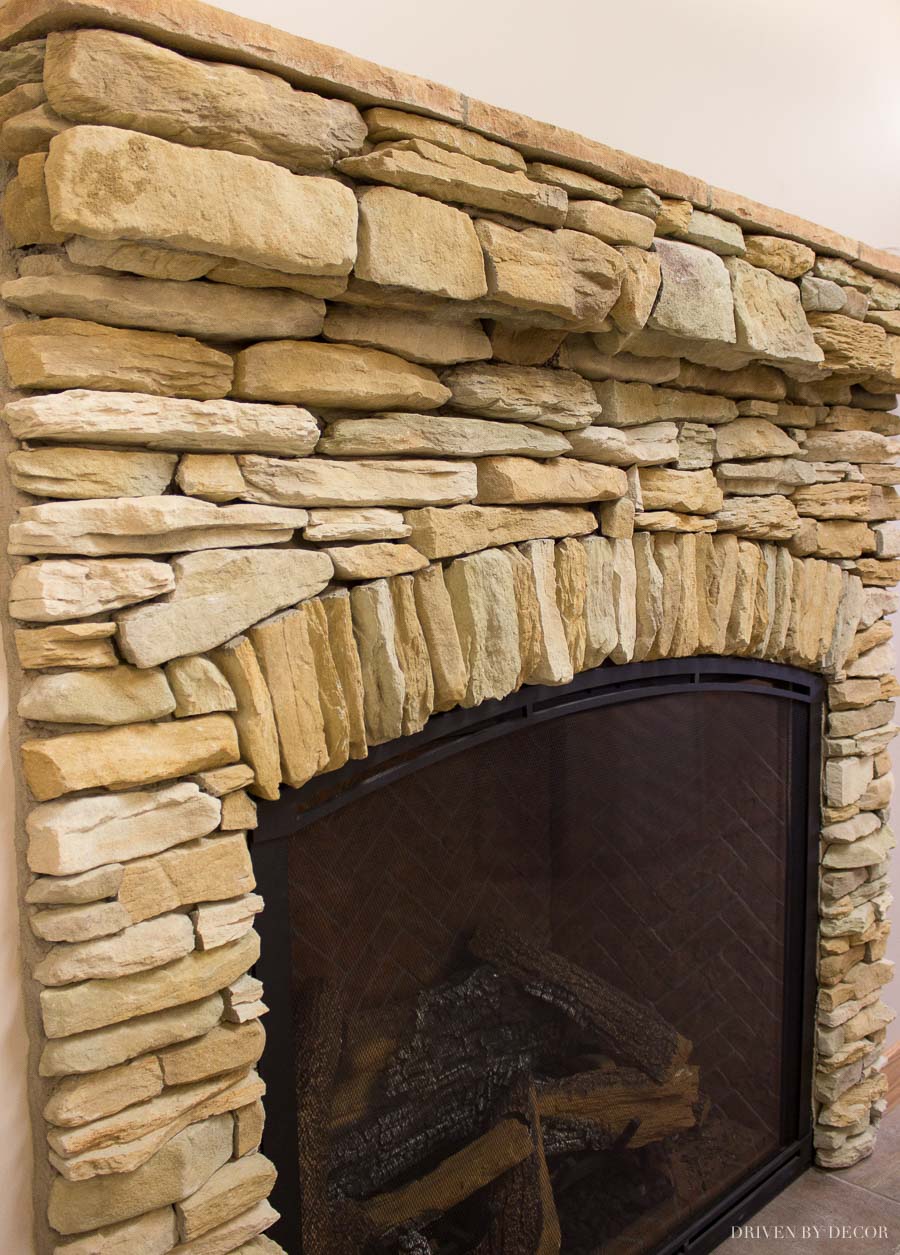 Loving the arched stone accent on this stone veneer fireplace