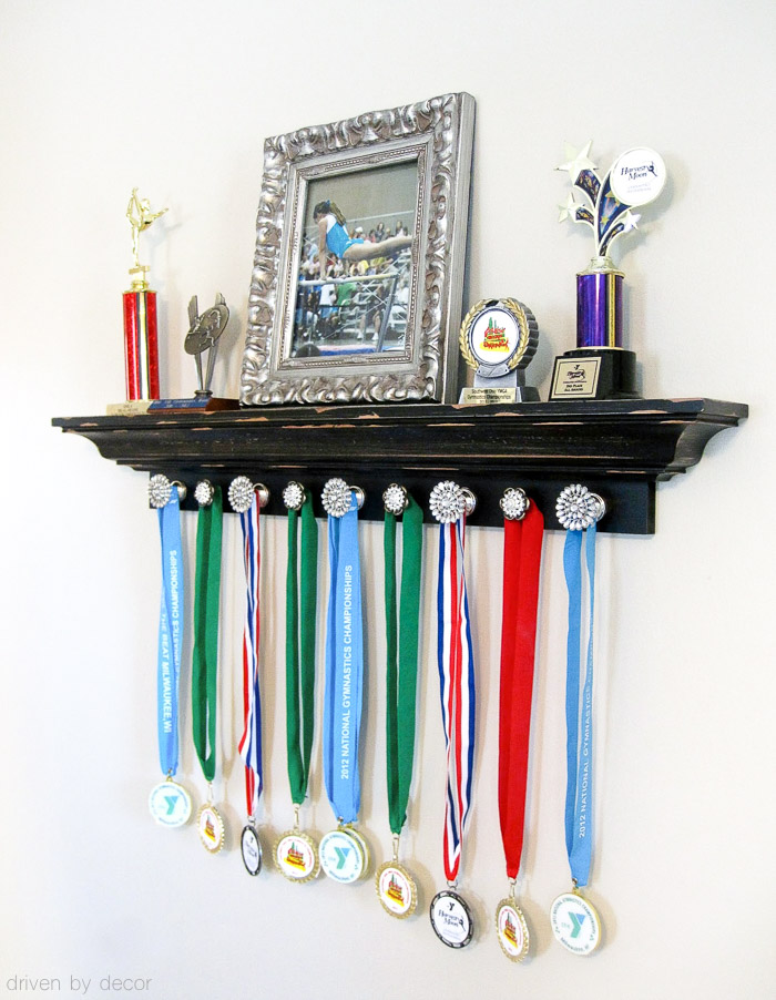 Such a cute way to display your kid's trophies and medals - shelving for the trophies and knobs for medals!