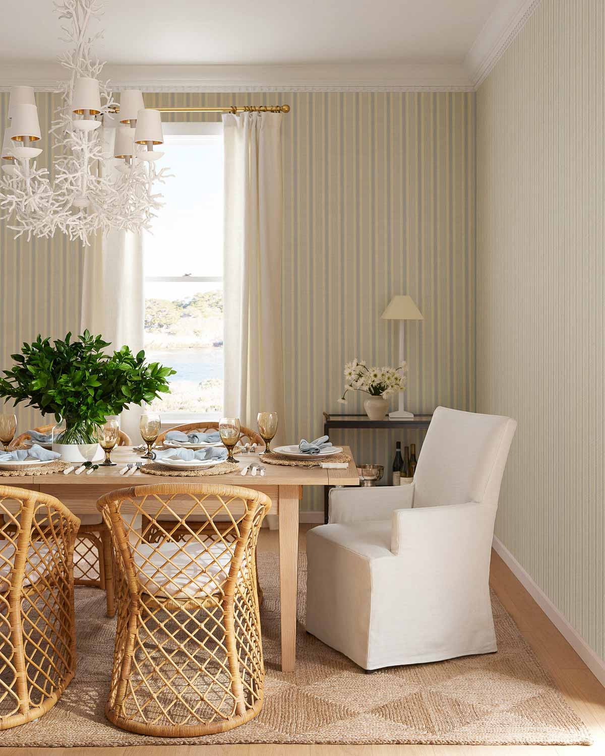 Rectangular dining table with rattan chairs on the sides and upholstered armchairs on the ends