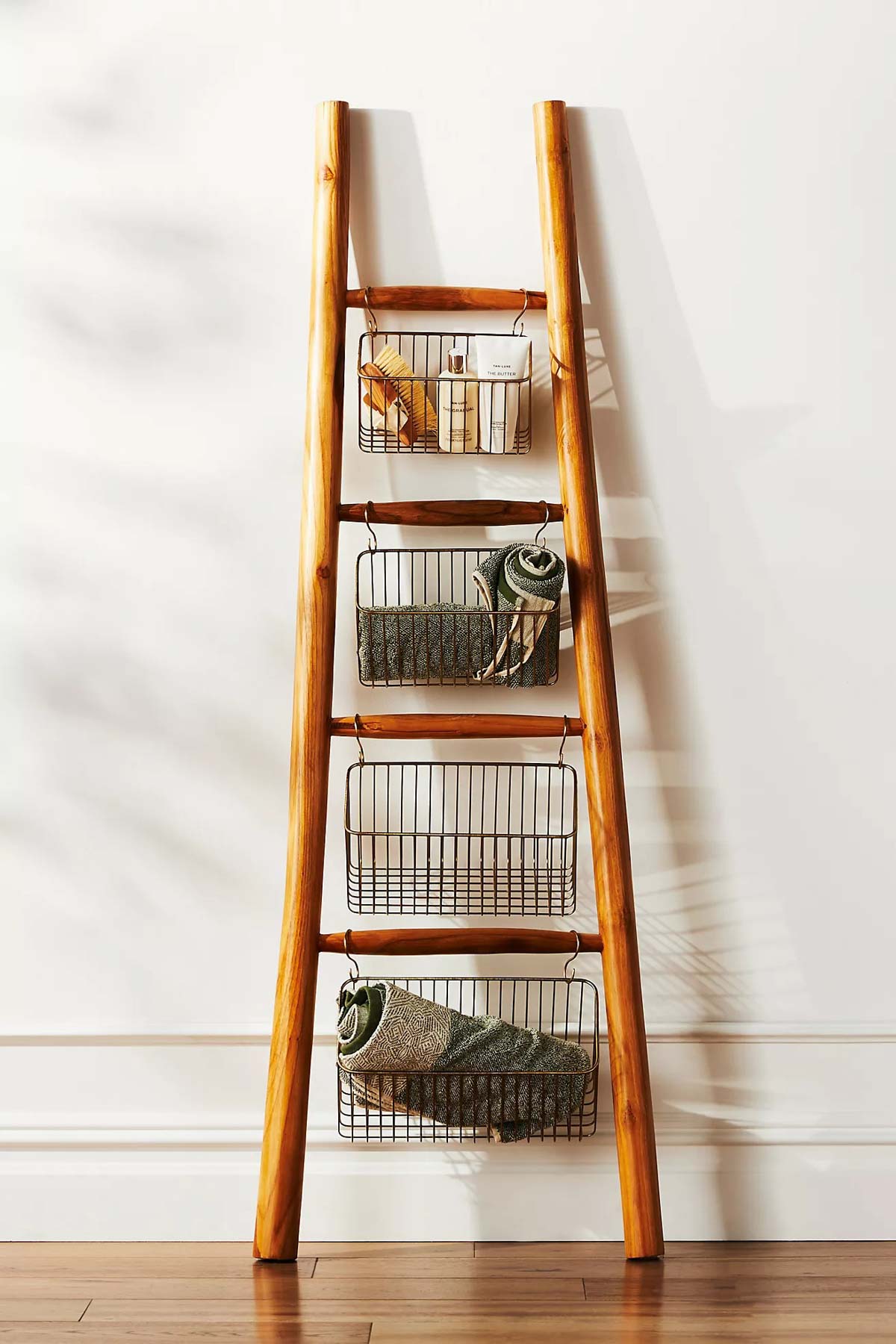Decorative ladder with wire bins hanging from rungs