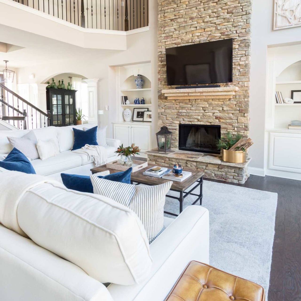 Love the way they mounted this TV over the two-story fireplace to look like it's resting on the mantel