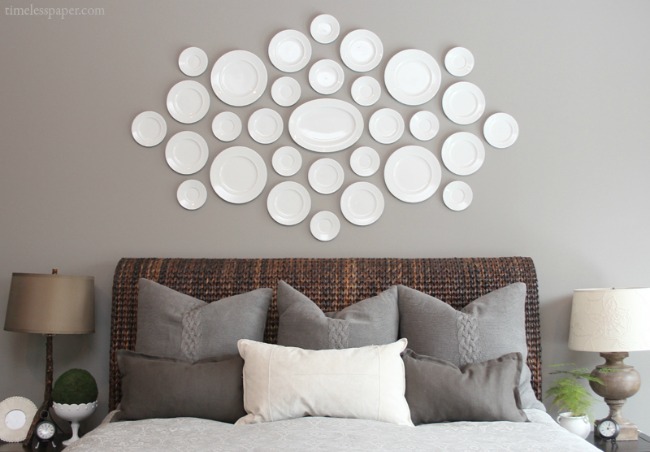 A collection of plates hung over the bed is a beautiful way to fill that awkward space!