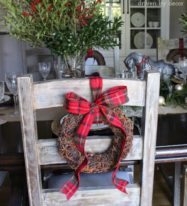 Star anise wreaths hung with plaid ribbon on the backs of dining room chairs - love this for Christmas!