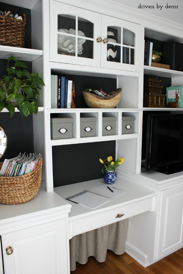 Home office bookcase with black backdrop and skirt under desk to hide cord clutter