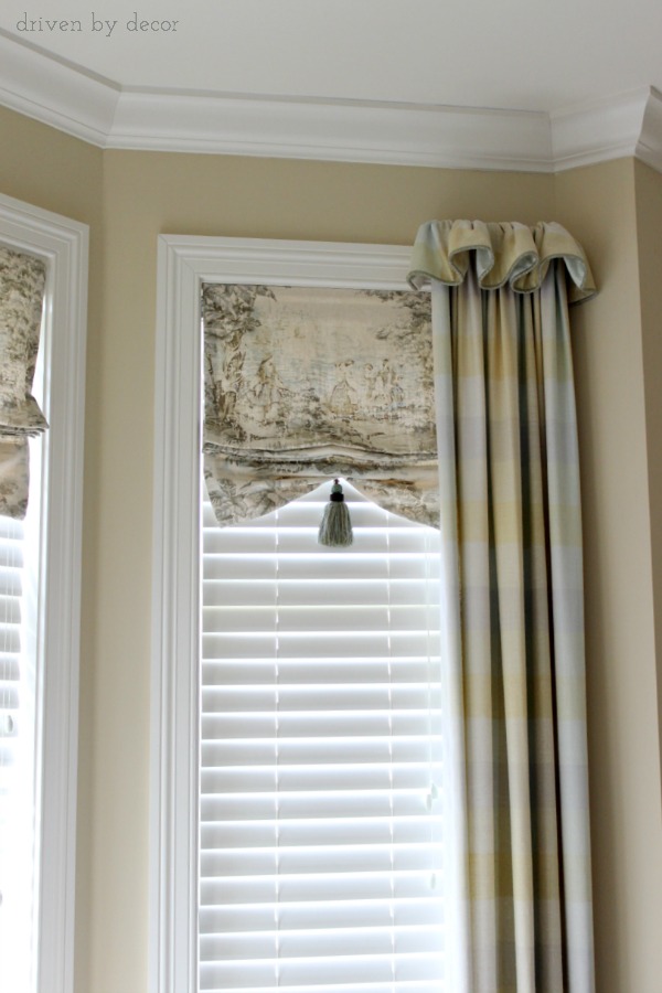 Bay window with faux shades and drapes framing ends