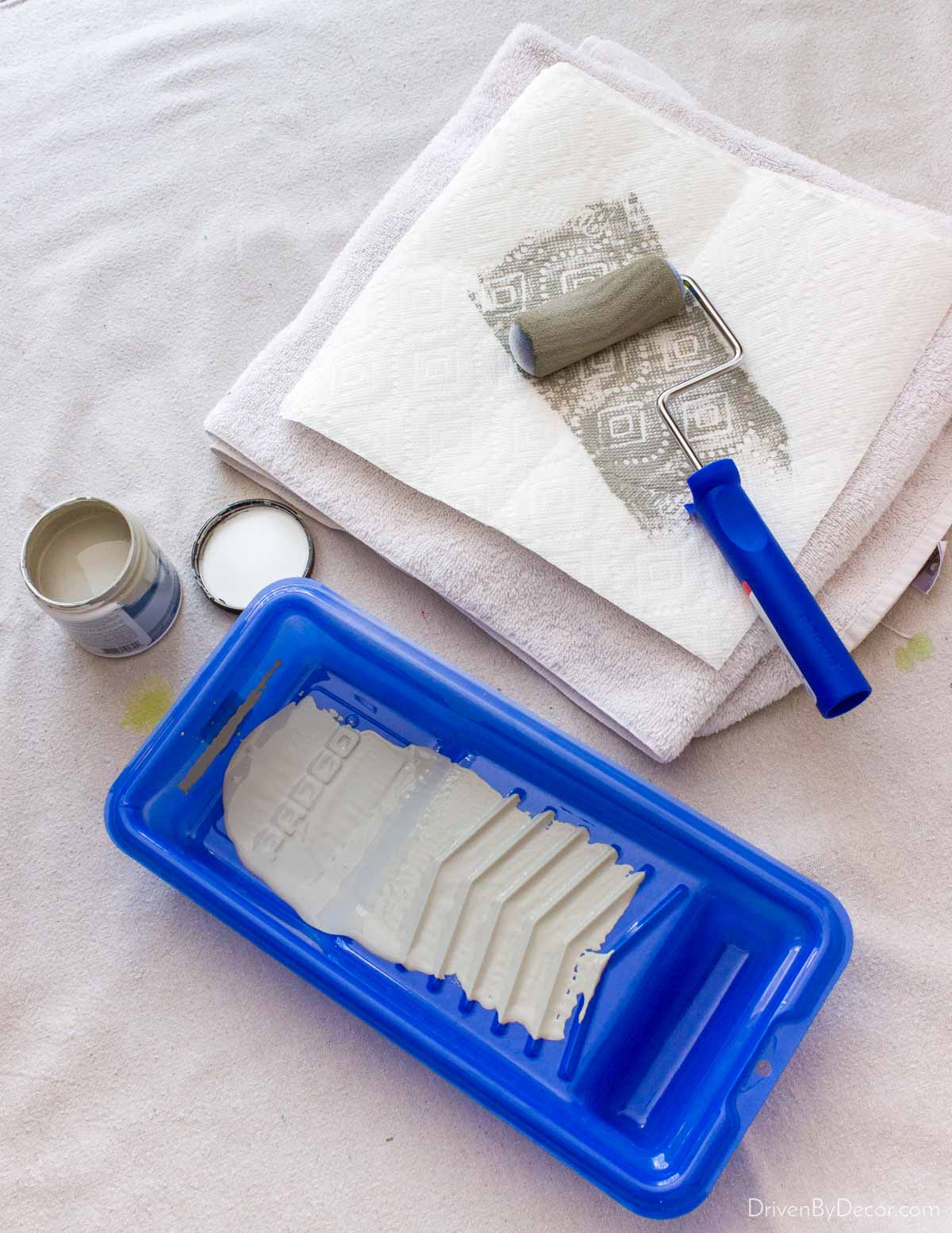 Running foam roller over stack of paper towels to minimize paint on roller