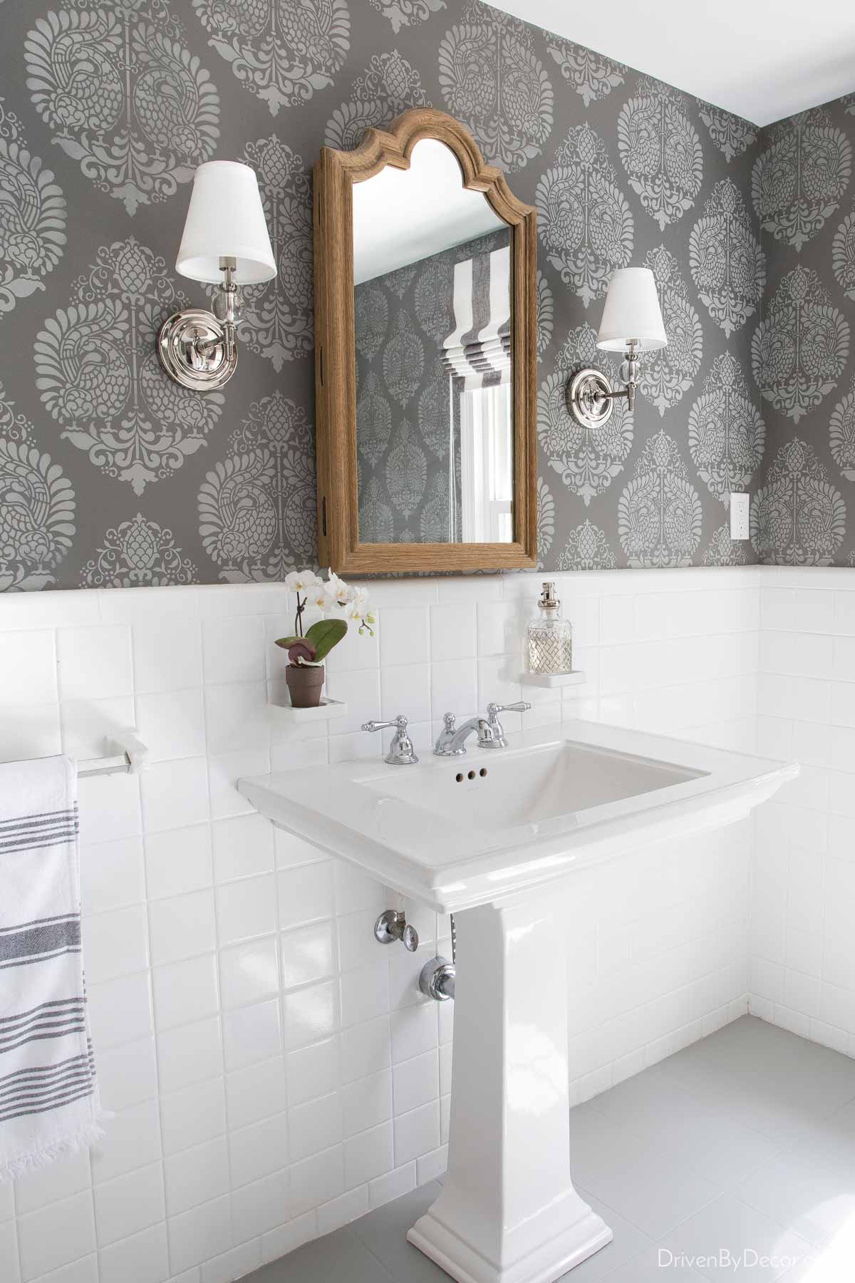 Powder room sink with wall stencils used to create wallpaper-like pattern on walls