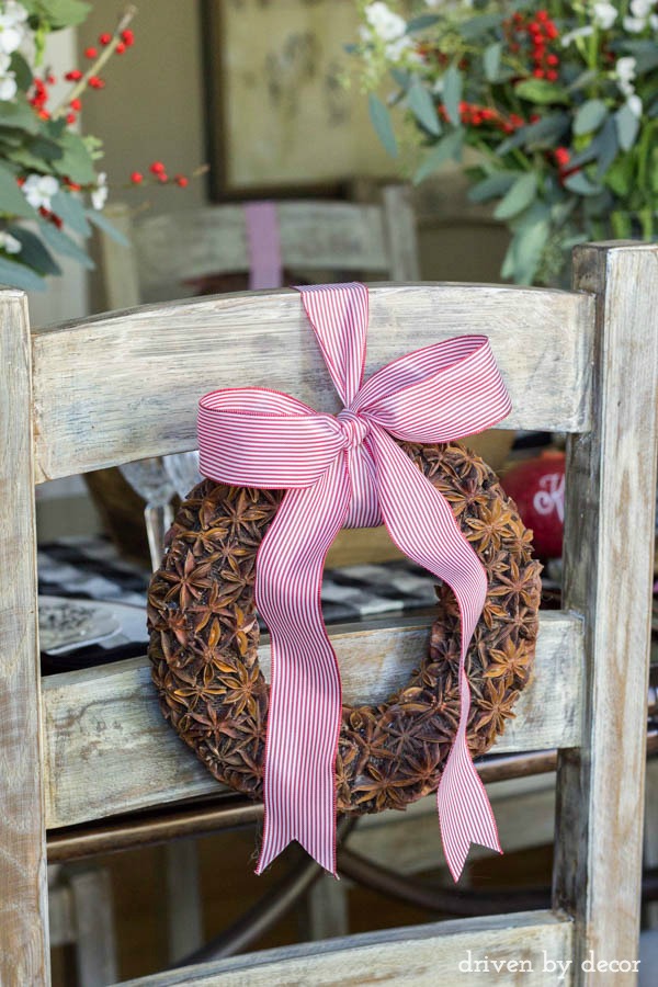 Fragrant star anise wreaths tied onto ladderback dining chairs are part of this festive holiday table