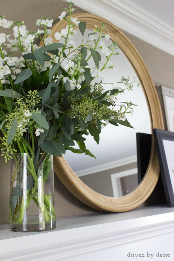 Round wood mirror on fireplace mantel