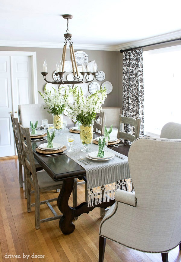 Dining room with simple Easter table decorations - floral centerpieces in vases lined with lemon slices and bunny ear napkins. Great ideas!