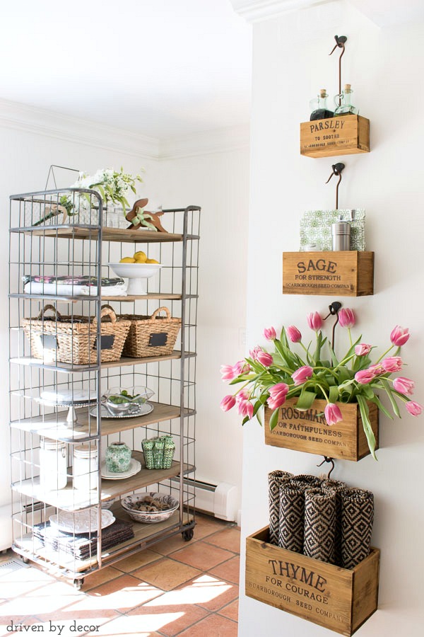 Kitchen with farmhouse style - wall-mounted nesting herb crates filled with tabletop necessities and farmhouse baker's rack