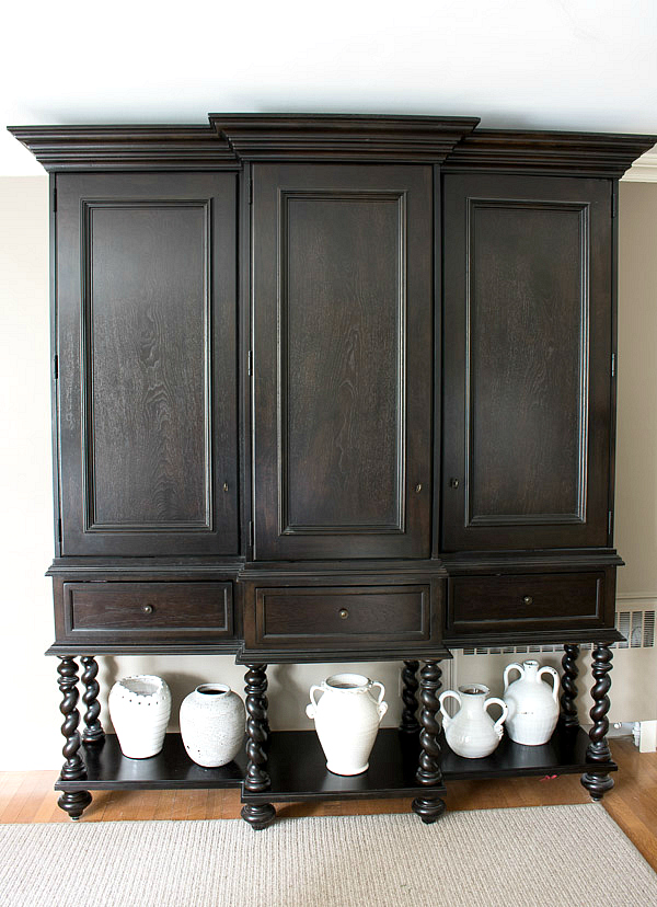Tall ebony stained china cabinet with spiral legs