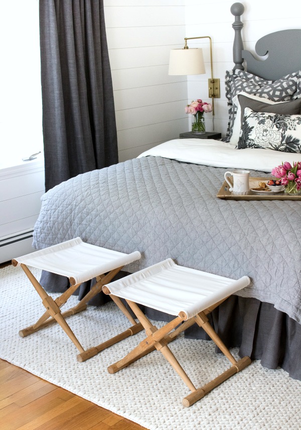 A pair of camp stools at the foot of the bed provides a great spot to stack bed pillows at night and to sit on while getting dressed in the morning!