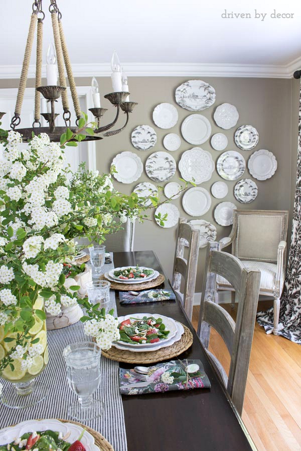 Love the plate wall in this neutral dining room that's decorated for spring