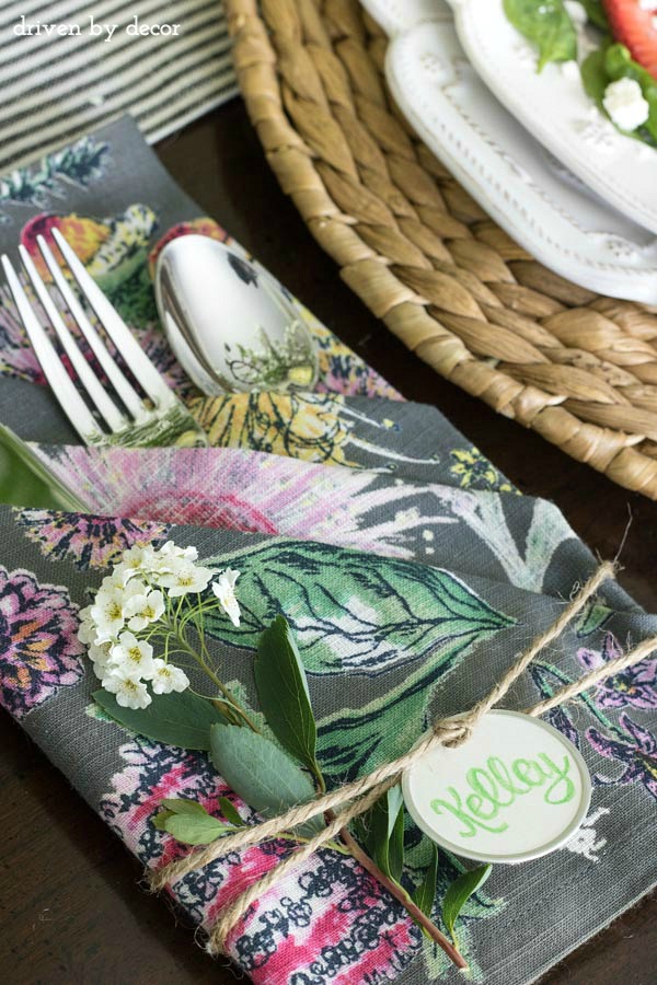 Napkins folded to create pouches for silverware with simple name tags tied on with twine - love!