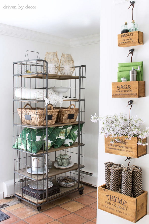 Open shelving holds patio pillows and accessories while nesting herb crates hold the tabletop necessities for the kitchen eat-in area