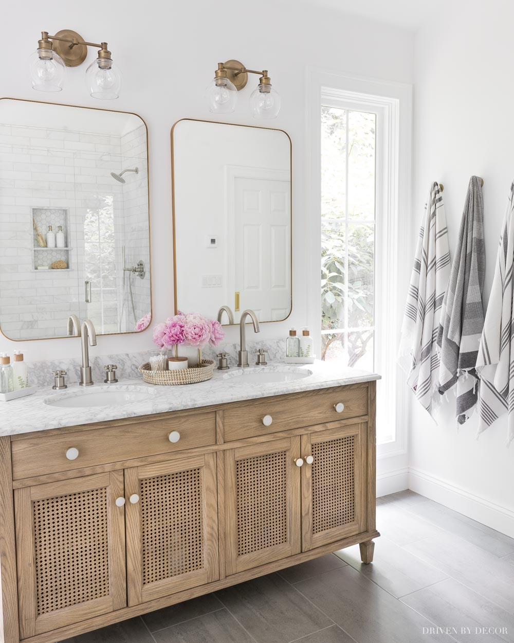 Love the mixed metals in this bathroom design! Brushed nickel faucets and brass / gold mirrors and lights