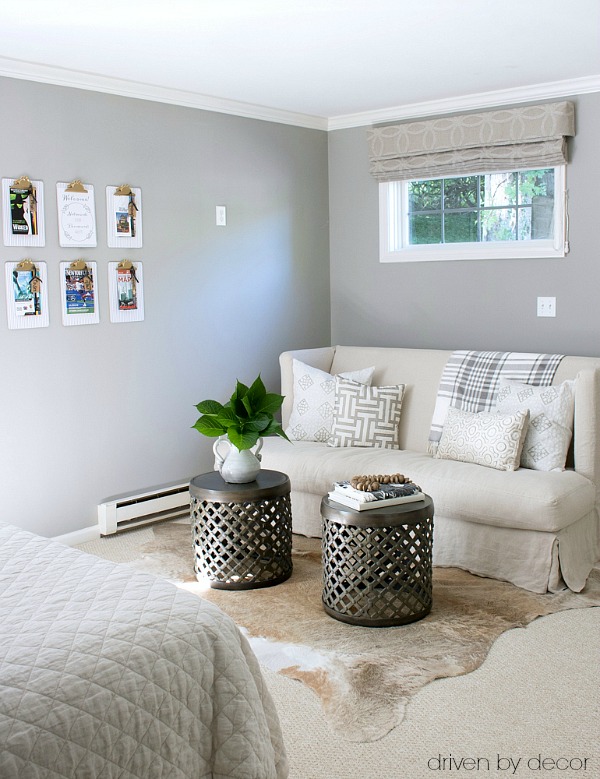 Guest room seating area with slipcovered loveseat and twin drum tables