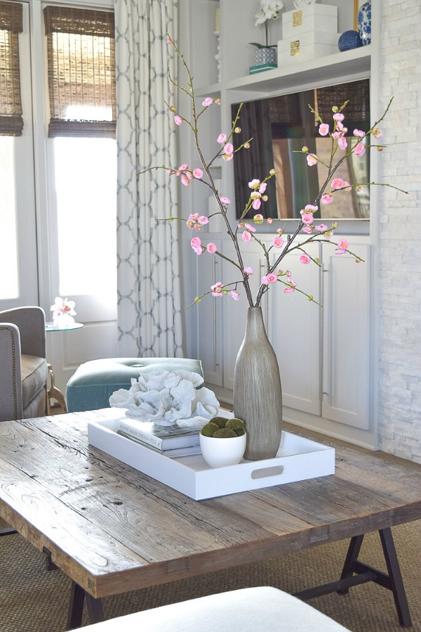 One coffee table styling tip is to incorporate natural elements like coral or plants