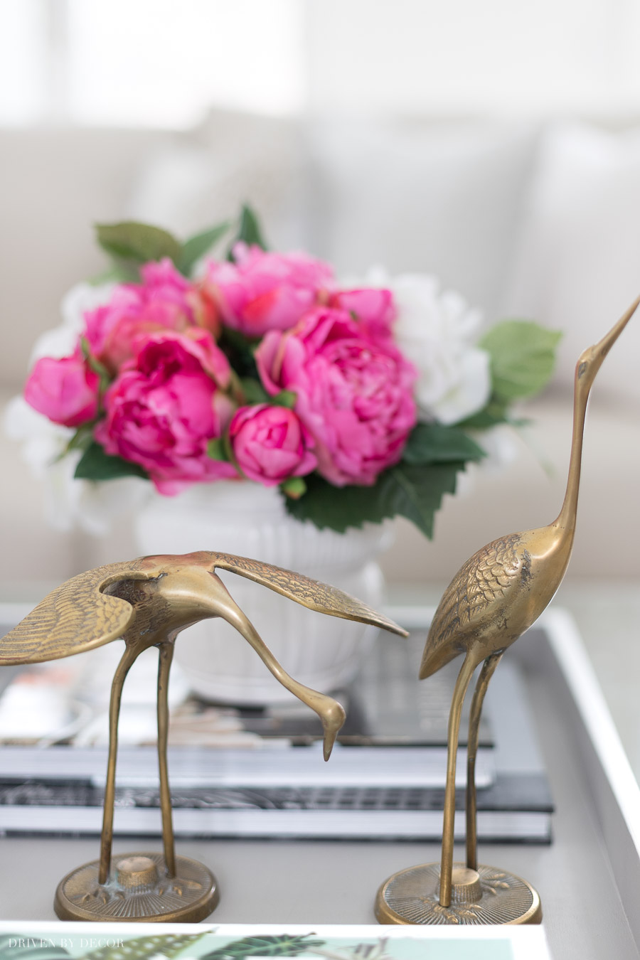 A pair of vintage brass cranes used as coffee table decor