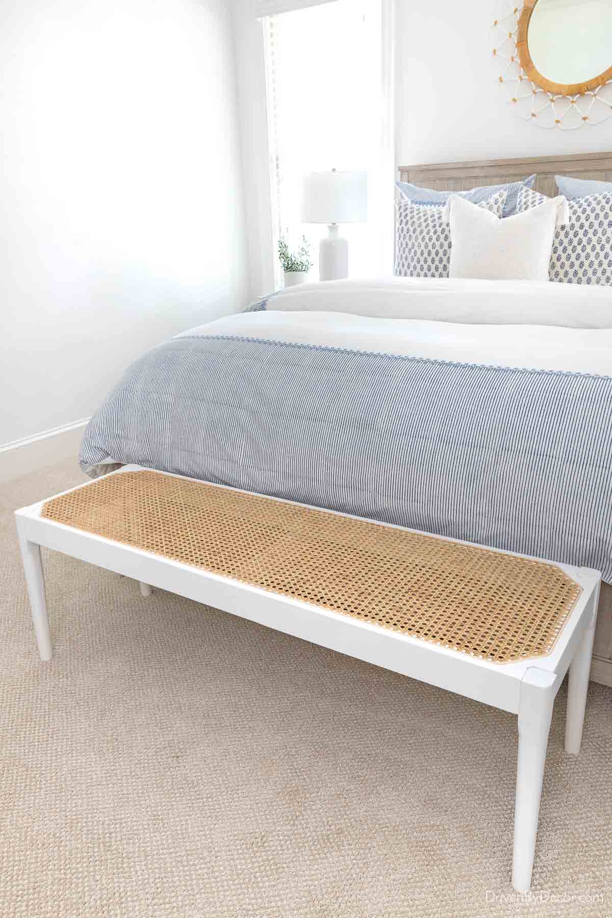 Cane bench at the end of a bed to use as a luggage rack