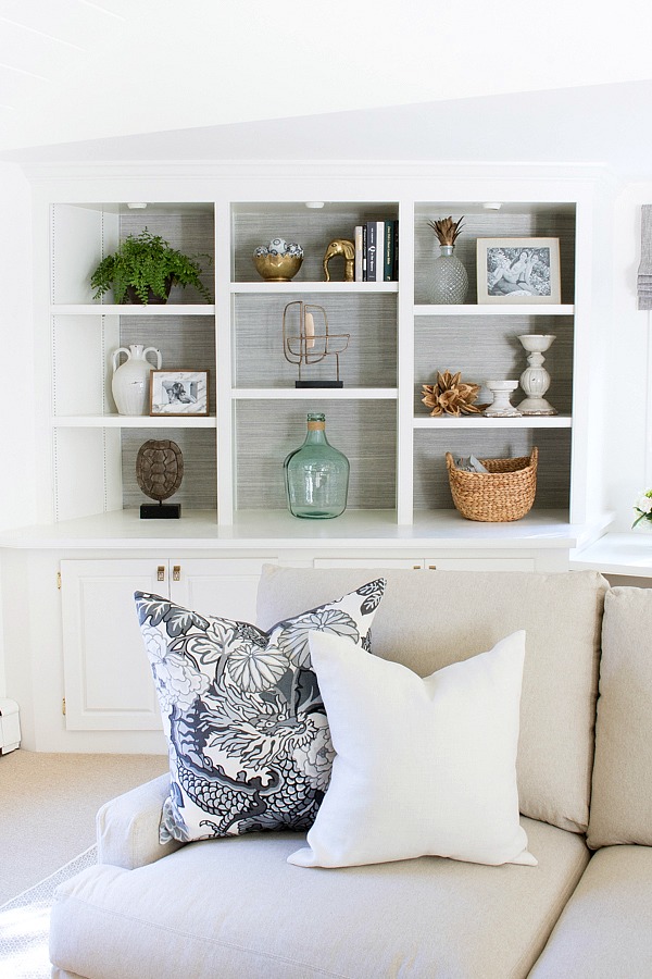 Built-in bookcases lined with grasscloth and simply styled