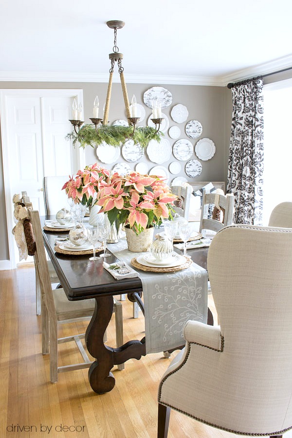 Christmas home tour - dining room decorated with pink poinsettias and gold and silver ornaments and decorative trees. Simple and beautiful!