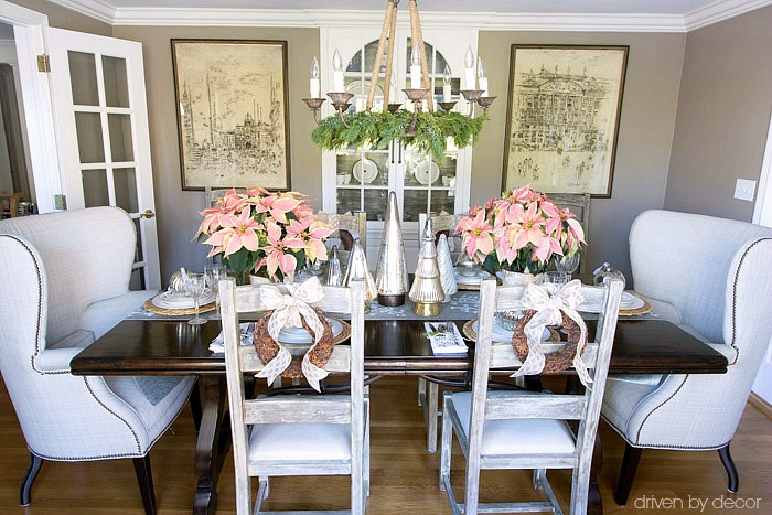 Christmas home tour - dining room table decorated for Christmas with a mix of silver and gold and pink poinsettias