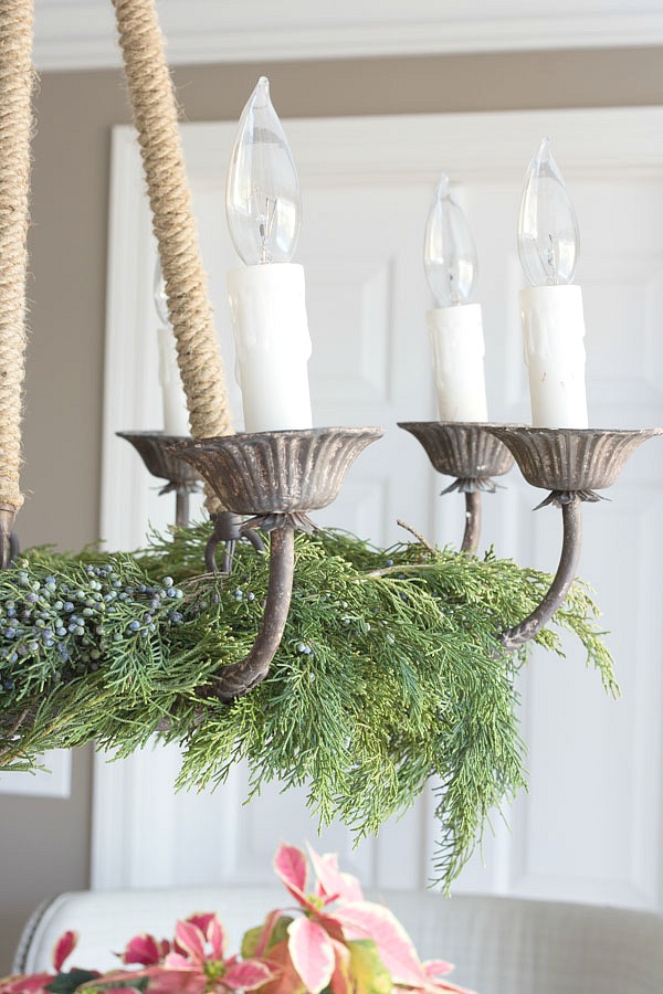 Christmas home tour - lay evergreen branches on the base of your chandelier for a simple, elegant Christmas table