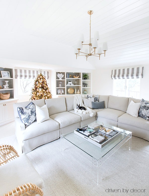 Christmas house tour of neutral living room with vaulted planked ceilings, a slipcovered sectional, acrylic coffee table, and more!