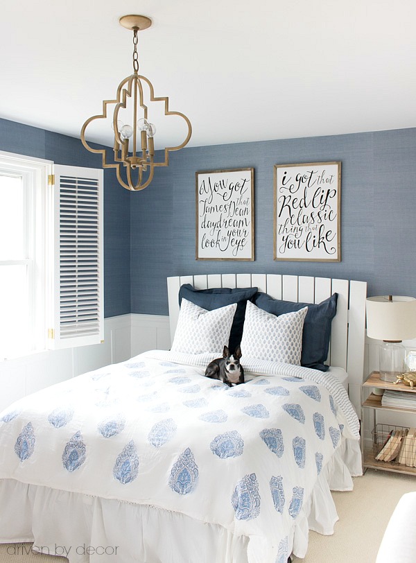 A classic white slatted headboard allows the grasscloth wallpaper and gorgeous blue and white bedding to shine!