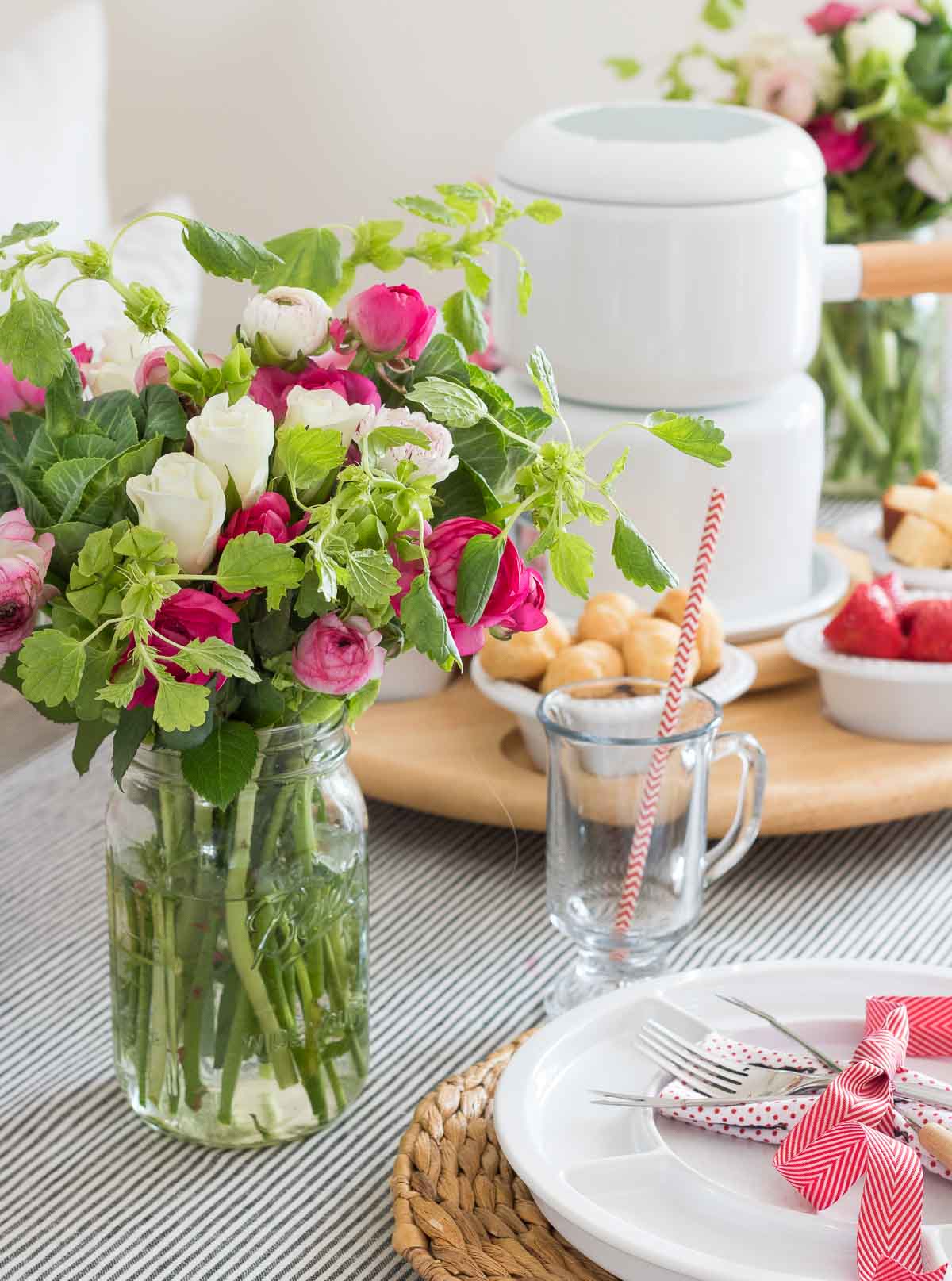 Bouquet of flowers on table set for fondue dinner