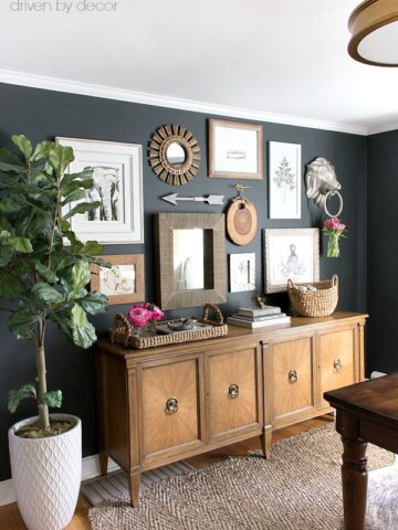 Great gallery wall arrangement with art prints and mirrors above a vintage console