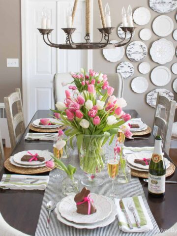 Easter table decor ideas - vase of tulips and chocolate bunnies on plates in dining room