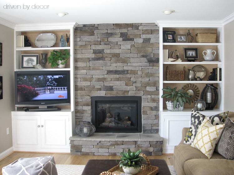 Family room with stone fireplace flanked by built-in bookcases