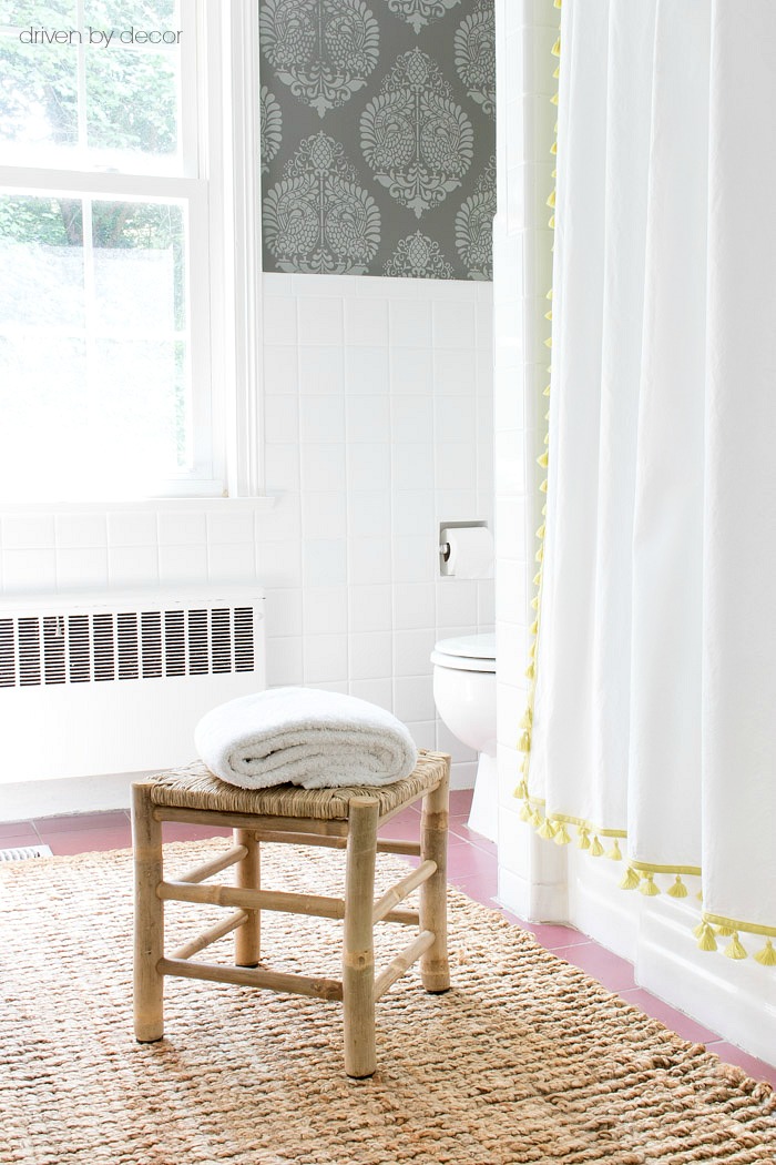 A small woven stool from HomeGoods is perfect for keeping a towel outside of the shower