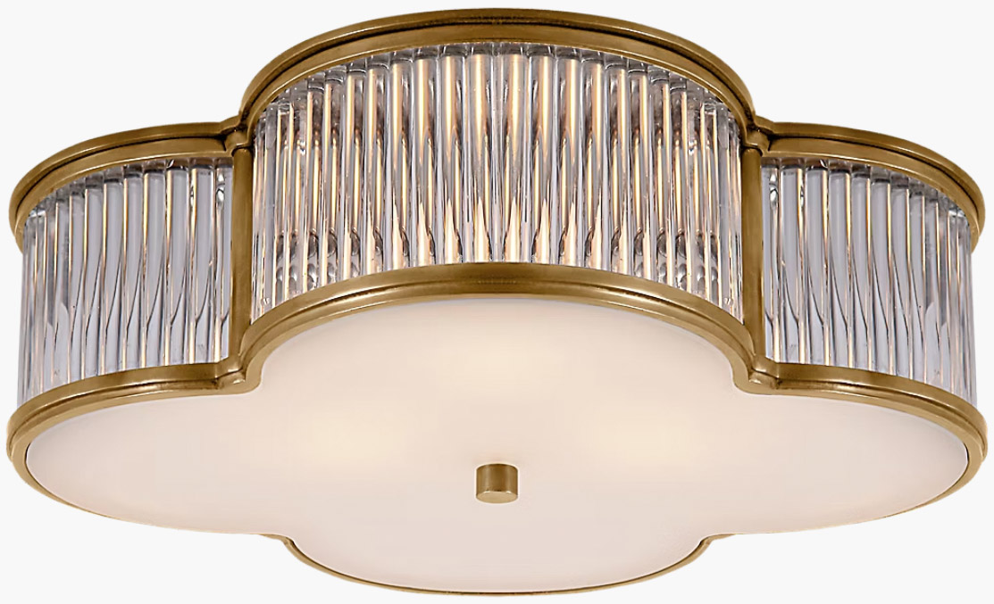 Clover-shaped flush mount light fixture lined in brass with glass rods