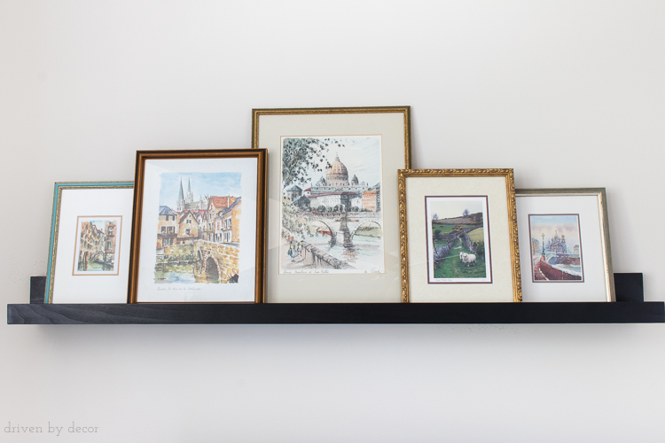 When arranging art on a ledge shelf, overlapping framed prints creates a more cohesive look!