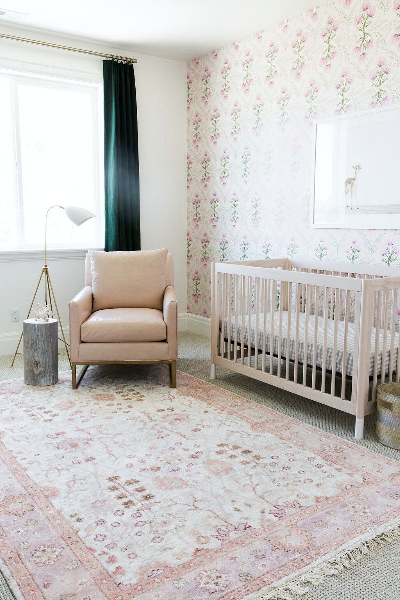 Beautiful baby's room with gorgeous pink patterned rug and focal wall with wallpaper
