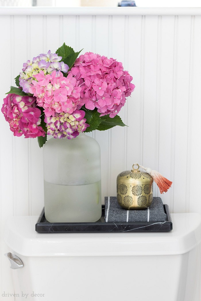 A black marble toilet tray is perfect for corralling a few accessories on top of the toilet tank!