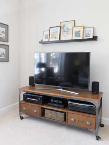 Love this solution for the bare wall above your flat screen TV! Art is on a ledge shelf so can be swapped in and out easily!