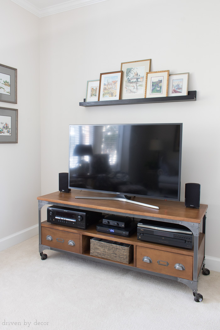 Love this solution for the bare wall above your flat screen TV! Art is on a ledge shelf so can be swapped in and out easily!