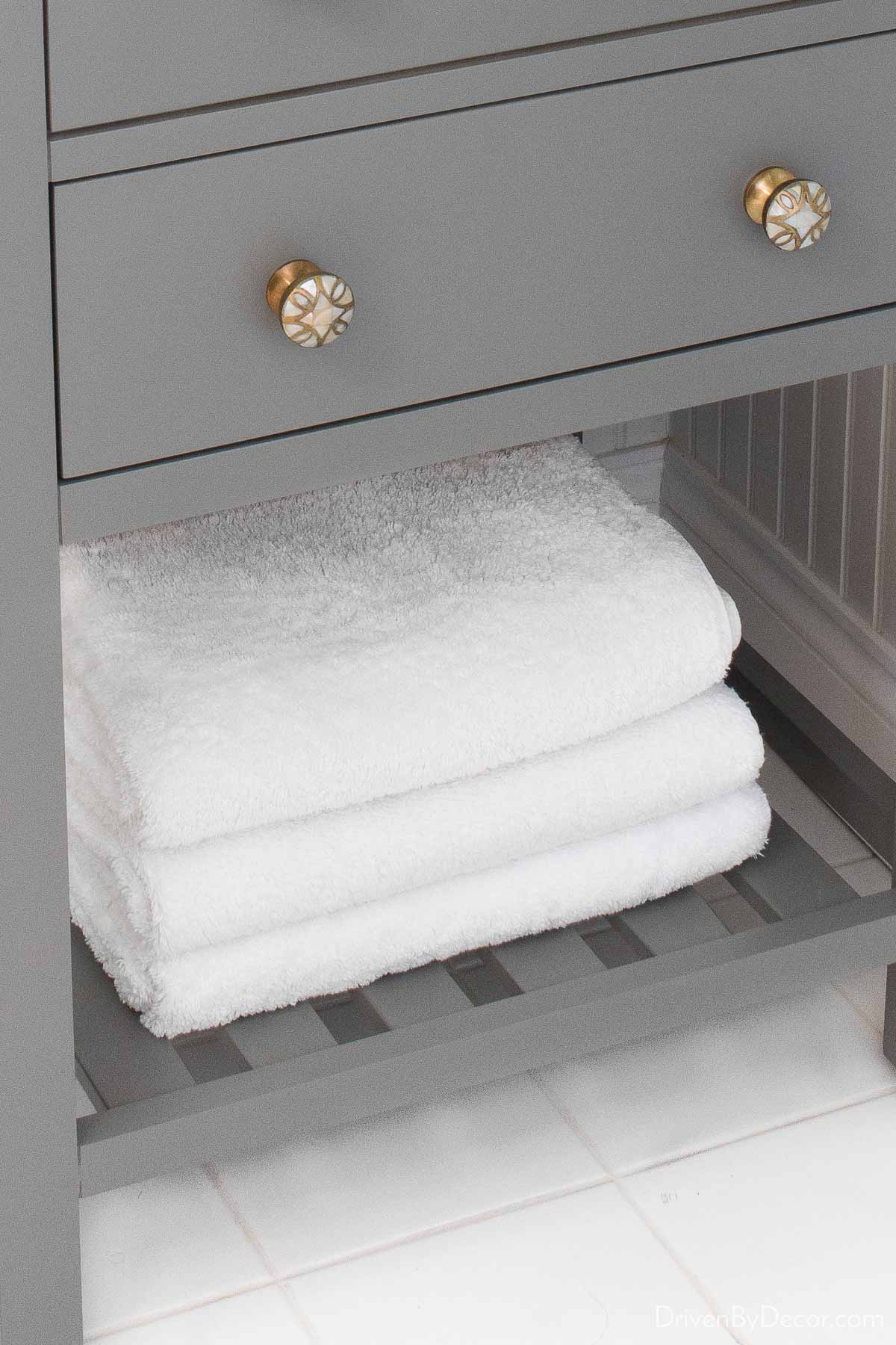 Guest bathroom towels on the shelf of our vanity
