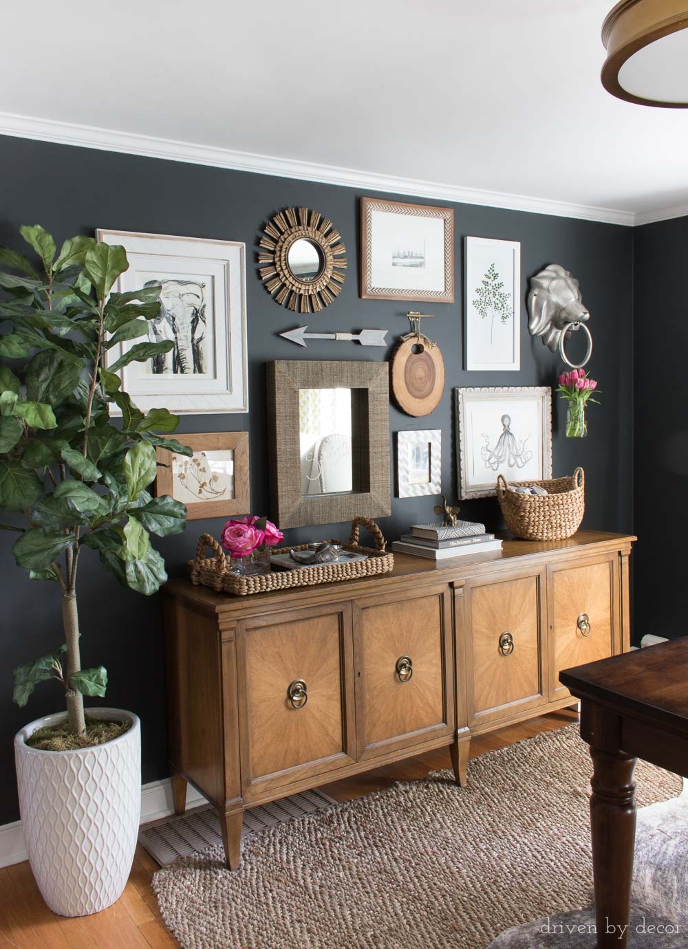 Love the mix of art and mirrors in this gallery wall hung on black walls with brass room accents